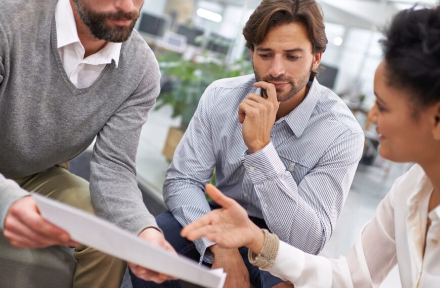 Business people making decisions over paperwork - banner